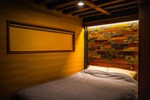 a bed in a room with a brick wall at Nikko Cottage Yurt in Nikko