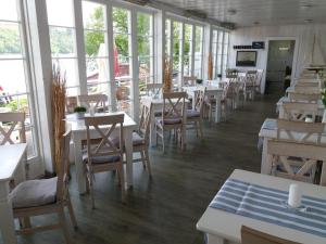 ein Restaurant mit Tischen, Stühlen und Fenstern in der Unterkunft Strandhaus Nr. 12 in Waldeck