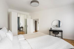 a white bedroom with a bed and a mirror at CITY CENTER- stylish & sunny Appartement in Vienna