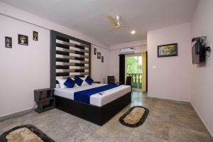 a bedroom with a large bed with blue pillows at Casa Da Village Calangute Goa in Calangute
