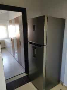 um frigorífico de aço inoxidável num quarto com um espelho em Fun Apartament Militari Residence em Roşu