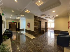 a lobby of a building with chairs and a fireplace at Al Deyafah Narjis-الضيافة نرجس in Khamis Mushayt