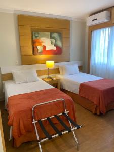 um quarto de hotel com duas camas e uma janela em Suíte Aeroporto Congonhas em São Paulo