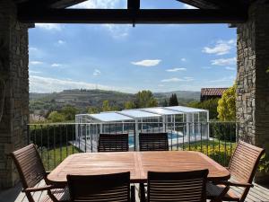 Montegrosso dʼAstiにあるLa Casa Bluの木製テーブルと椅子付きのバルコニーから眺めの良い景色を楽しめます。