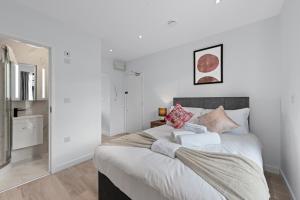 um quarto com uma grande cama branca com almofadas em Lovely 1 Bedroom with outdoor space em Londres