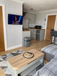a living room with a table and a kitchen at 265 Belle Aire, Modern Property in Hemsby