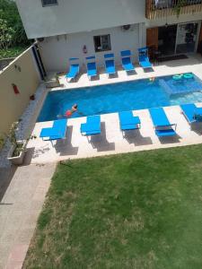 - une piscine avec des chaises bleues et une personne dans l'eau dans l'établissement A & A TERANGA, à La Somone