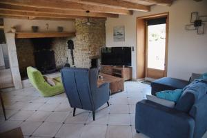 ein Wohnzimmer mit einem Sofa und einem Kamin in der Unterkunft Gîte de la bergerie côte d'Opale in Souverain-Moulin