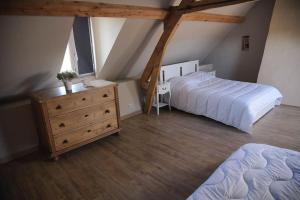 ein Schlafzimmer mit 2 Betten und einer Kommode im Dachgeschoss in der Unterkunft Gîte de la bergerie côte d'Opale in Souverain-Moulin
