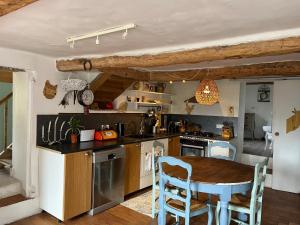 una cucina con tavolo in legno, tavolo e sedie di Domaine du Cruvelet Grand gite a Trigance