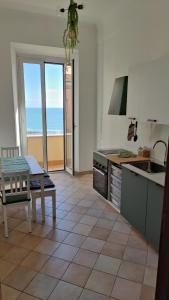 a kitchen with a table and a view of the ocean at BellaVista, il tuo soggiorno vista mare! in Nettuno