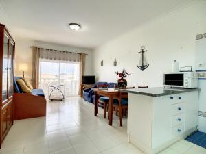 O Cantinho do Algarve في بورش: مطبخ وغرفة معيشة مع أريكة وطاولة