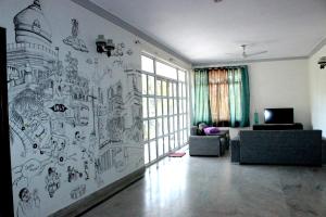 a living room filled with furniture and a painting on the wall at Social Rehab in Bangalore