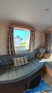 タターズホールにあるTattershall Lakes, Castle Viewの大きな窓のある客室で、ソファが備わります。