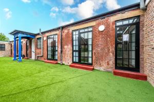 an empty courtyard of a brick building with green grass at Lovely 1 Bedroom with outdoor space in London