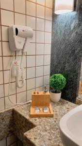 a bathroom with a hair dryer on a counter at Lindo Flat Particular decorado in Brasilia