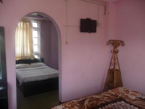 A bed or beds in a room at Pashupati Darshan Hotel