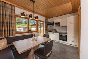 eine Küche und ein Esszimmer mit einem Holztisch und Stühlen in der Unterkunft Haus Steirerland in Schladming