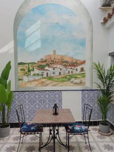 une table avec deux chaises et un tableau sur le mur dans l'établissement Unique Village House, à Jimena de la Frontera