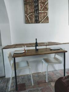 een tafel met 2 stoelen en een fles wijn bij Unique Village House in Jimena de la Frontera