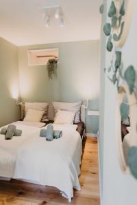 two beds in a room with white sheets at Stylisches Apartment im Herzen Leipzigs mit Balkon in Leipzig