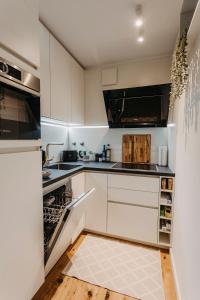 a kitchen with white cabinets and an open dishwasher at Stylisches Apartment im Herzen Leipzigs mit Balkon in Leipzig