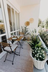 eine Veranda mit Stühlen, einem Tisch und Topfpflanzen in der Unterkunft Stylisches Apartment im Herzen Leipzigs mit Balkon in Leipzig