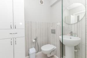 a white bathroom with a toilet and a sink at Apartament in zona Centrala si Parc in Chişinău +9 photos