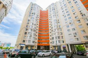 um grande edifício com carros estacionados em frente em Apartament in zona Centrala si Parc em Chisinau