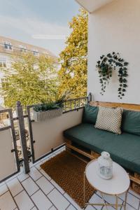 a balcony with a green couch and a table at Stylisches Apartment im Herzen Leipzigs mit Balkon in Leipzig