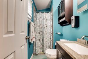 y baño con aseo y cortina de ducha. en Escape to our cozy 3 Bed Rm 2 Bath Unit in Alexandria VA, en Alexandria