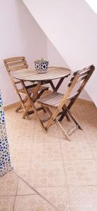 un tavolo in legno con 2 sedie, un tavolo e un tavolo di Riad Soul of Tetouan a Tétouan