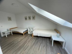 a attic room with two beds and a table at Ferienwohnung über den Dächern von Pinnow in Pinnow