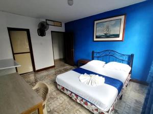 a bedroom with a bed with a blue wall at Hostal El Rey in Buenaventura