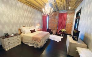 - une chambre avec un lit et un lustre dans l'établissement Mulberry Inn, à Tishomingo