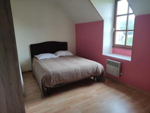 Schlafzimmer mit einem Bett und einem Fenster in der Unterkunft Gîte de la Forêt in Saint-Jeanvrin