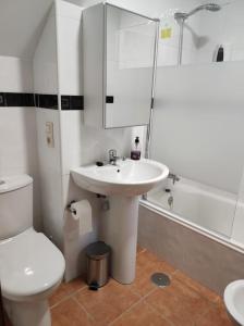 a white bathroom with a sink and a toilet at Villa Quijada in Trefacio +15 photos