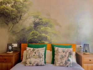a bedroom with a bed with a painting on the wall at Casa Rural Una Ventana a la Sierra in Aracena