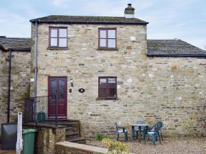a brick house with a table and chairs in front of it at Moordale Cottage in Reeth