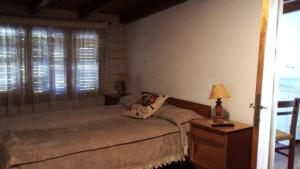 a bedroom with a bed and a table with a lamp at Victoria in Esquel