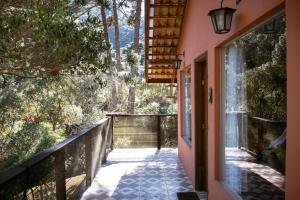 a walkway leading to a house with a balcony at Chalé da Mata in Sapucaí-Mirim