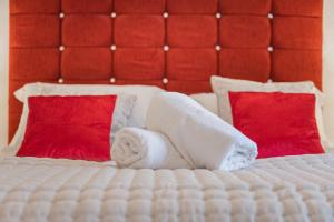 - un lit avec 2 serviettes et 2 oreillers rouges dans l'établissement Cottage 3 Old Farmhouse Mews, à Keswick