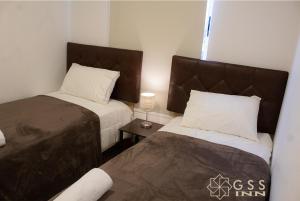 a bedroom with two beds and a table with a lamp at Beautiful apartment Near airport /cozy Oceanfront in Lima +13 photos