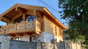 a house with a balcony on top of a wall at Chalet Bakuriani in Bakuriani