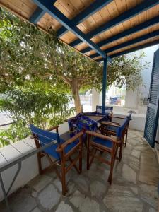 a table and chairs on a patio with a tree at Villa Gelly's Studios in Aliki