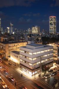 a lit up building with a city at night at DeBlox living - Ben Avigdor Apartments in Tel Aviv
