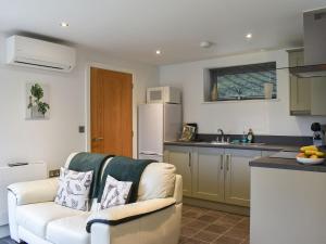 a living room with a couch and a kitchen at The Harwell in Assington