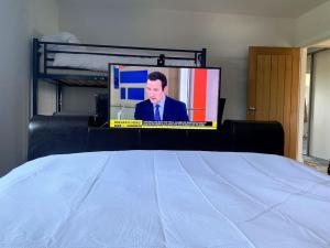 a bed with a tv on top of it at Ranch House in Preesall