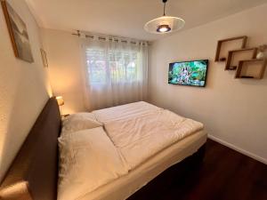 a small bedroom with a white bed and a window at Apartment im Emmental in Oberburg