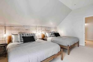 1 dormitorio con 2 camas y pared de madera en Luxury Retreat en Mont-Tremblant